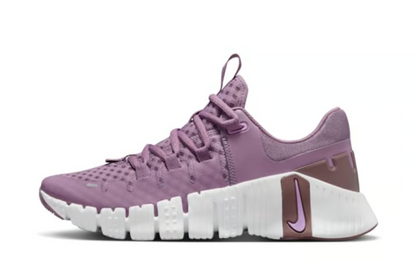 A pair of purple Nike Free Metcon 5 gym shoes for women, featuring a mesh upper material and a midsole with visible cushioning technology.